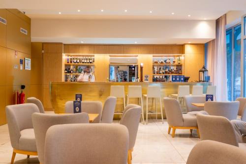 un restaurante con mesas y sillas y un bar en Smy Lisboa, en Lisboa