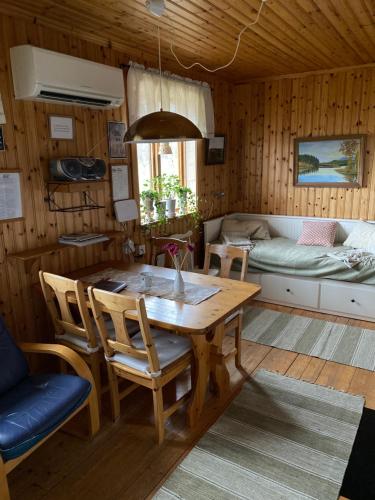 uma sala de jantar com uma mesa e um sofá em Backen em Torsby