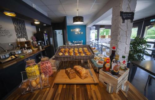 a bakery with a counter with pastries and other foods at Sure Hotel by Best Western Lille Tourcoing Ex Hotel Garden in Bondues