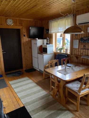 a kitchen and dining room with a table and a television at Backen in Torsby
