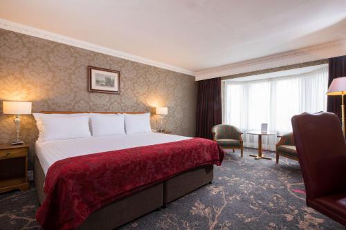 a hotel room with a large bed and a large window at Kingsmills Hotel in Inverness