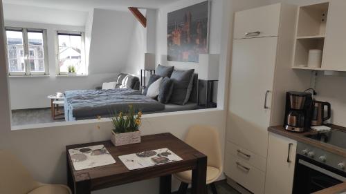 Cette petite chambre comprend un lit et une table. dans l'établissement Exklusive Ferienwohnung im Einzeldenkmal, à Quedlinbourg