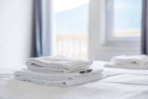 een stapel witte handdoeken zittend op een bed bij Mentenwirt Suite in Sankt Martin