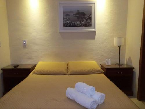 a bedroom with a bed with two towels on it at Pousada Village Tere in Teresópolis