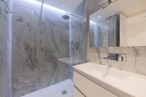 y baño con ducha, lavabo y bañera. en Center Bay Luxueux appartement avec vue mer 6 eme etage, en Juan-les-Pins