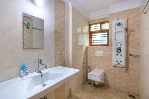 un bagno con lavandino, doccia e WC di Guesture Serviced Residences, Alta Vista a Bangalore