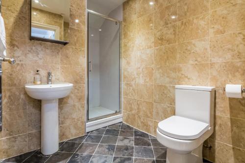 a bathroom with a toilet and a sink and a shower at Exclusive City Centre Apartment in Newcastle upon Tyne