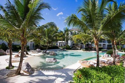 a swimming pool with palm trees in a resort at Casa en Paraiso RD in Bayahibe