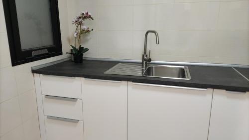a kitchen with a sink and white cabinets at CITY&SEA in Arrecife