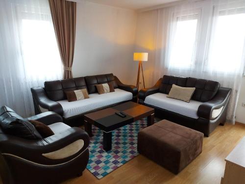 a living room with two couches and a table at City View - Downtown Apartment in Prishtina in Pristina
