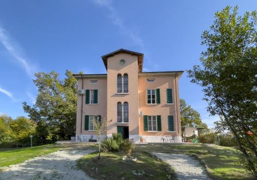 an old house on a hill with trees at Notte Rosa Suites & Relax in Fornovo di Taro