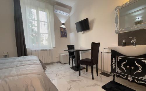 a bedroom with a bed and a table and a sink at Notte Rosa Suites & Relax in Fornovo di Taro