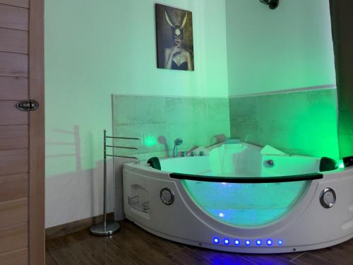 a bath tub in a bathroom with green and blue lighting at Notte Rosa Suites & Relax in Fornovo di Taro