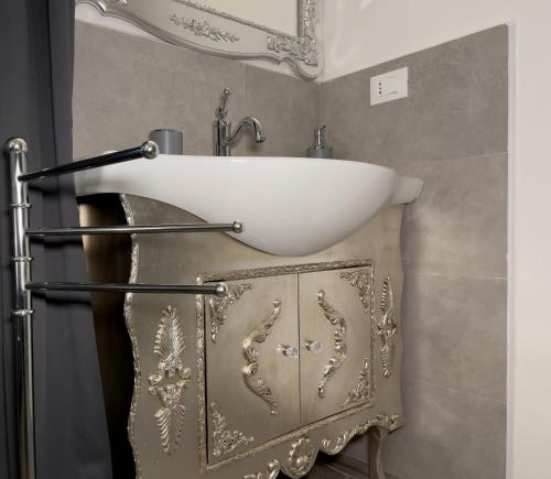 a bathroom with a white sink on a wall at Notte Rosa Suites & Relax in Fornovo di Taro