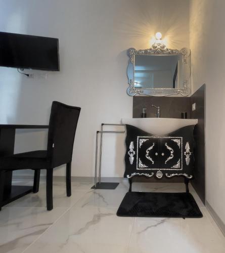 a room with a desk and a chair and a mirror at Notte Rosa Suites & Relax in Fornovo di Taro