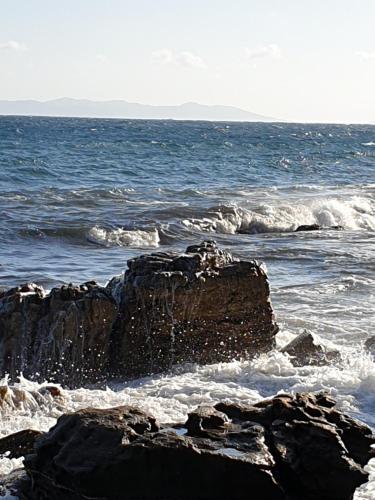 a rock in the ocean with the waves at Les Restanques du Sud in Le Lavandou