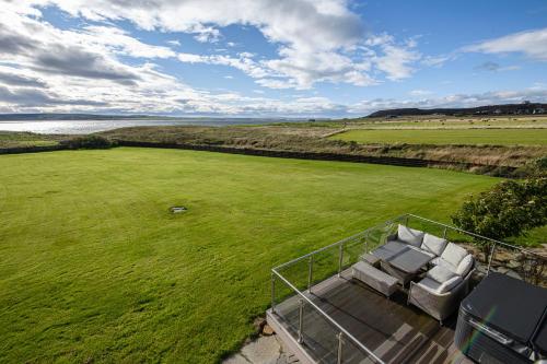 an aerial view of a large green field with chairs at Dunnet B&B Escapes in Dunnet