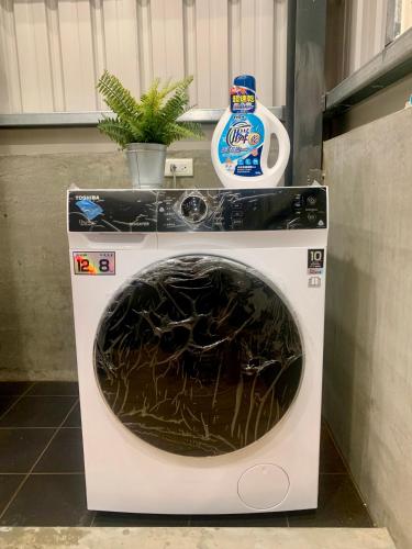 a washing machine with a bottle of detergent on top at 高雄好日子914包棟KTv民宿 in Kaohsiung