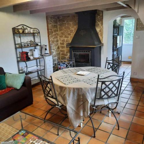 une salle à manger avec une table et une cheminée dans l'établissement AUX PORTES DU CHATEAU Cottage intimiste et cosy à l'abri des regards propice à la detente, à Rinxent