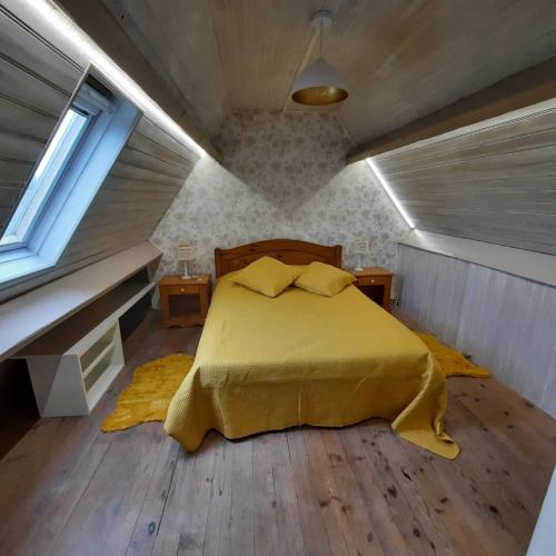 - une chambre mansardée avec un lit jaune dans l'établissement AUX PORTES DU CHATEAU Cottage intimiste et cosy à l'abri des regards propice à la detente, à Rinxent