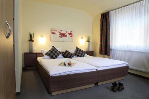 1 dormitorio con 1 cama grande con sábanas y almohadas blancas en Landgasthof Reinert en Reiste