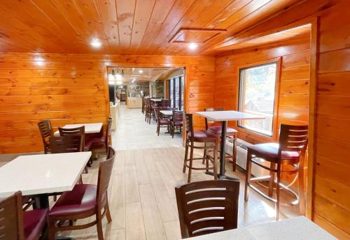 a restaurant with wooden walls and tables and chairs at Baymont by Wyndham Gatlinburg On The River in Gatlinburg