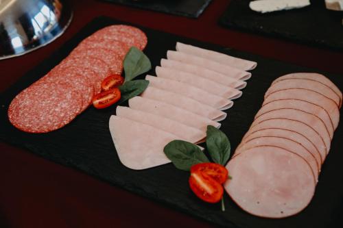 a plate with meats and vegetables on a table at Verslo Klasė-easy to stay in Panevėžys