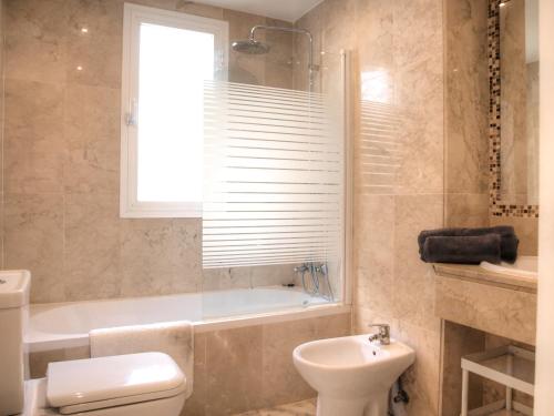 ein Badezimmer mit einer Badewanne, einem WC und einem Waschbecken in der Unterkunft Sun Beach Apartment in Estepona