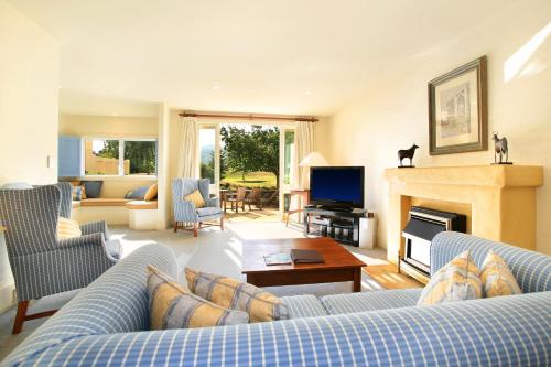 a living room with two blue couches and a fireplace at Millbrook Resort in Arrowtown