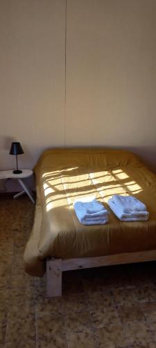 a bed in a room with two towels on it at Casona LA FLORIDA con parque y pileta, a una cuadra del río in Rosario