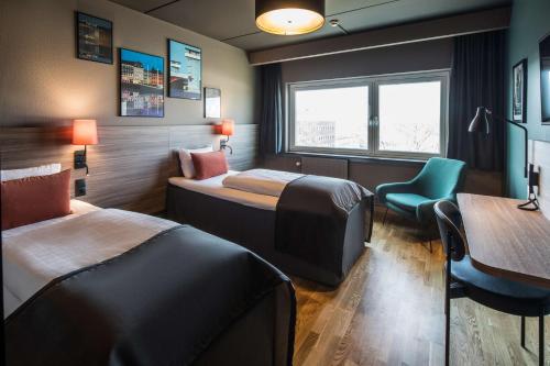 Scandic Glostrup في غلوستروب: غرفة فندقية بسريرين وطاولة وكرسي