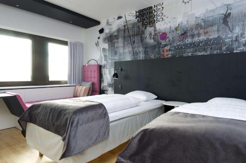 a bedroom with two beds and a wall with a mural at Scandic Copenhagen in Copenhagen