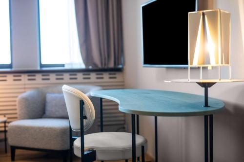 una mesa, una silla y una TV en una habitación en Scandic Copenhagen, en Copenhague