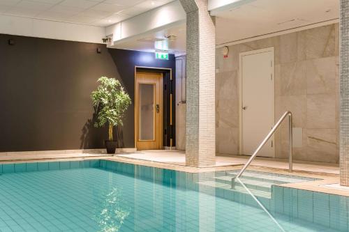 a large swimming pool in a lobby with a building at Scandic Gävle Väst in Gävle