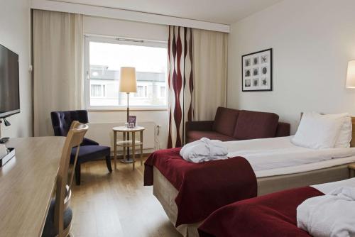 um quarto de hotel com uma cama e um sofá em Scandic Norrköping Nord em Norrköping