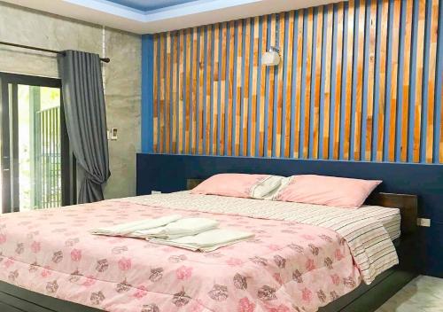 1 dormitorio con 1 cama con manta rosa en ใสโพธิ์โฮมสเตย์, en Phatthalung