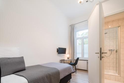 a small bedroom with a bed and a window at Hotel Aurora in Wiesbaden