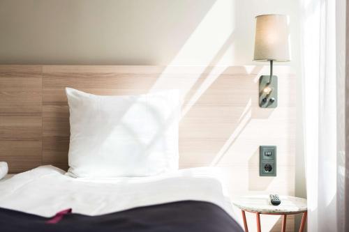 a bed with a white comforter and pillows at Scandic No 53 in Stockholm