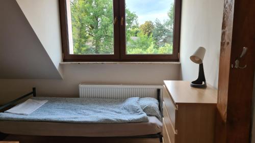 a small bedroom with a bed and a window at W20 Hostel in Golędzinów
