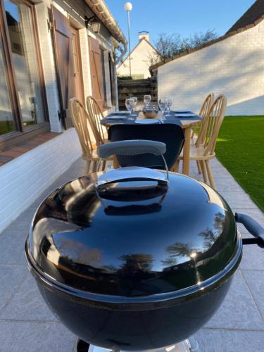 a table and chairs and a table and a bowl on a patio at vakantiehuisje 003 in Koksijde