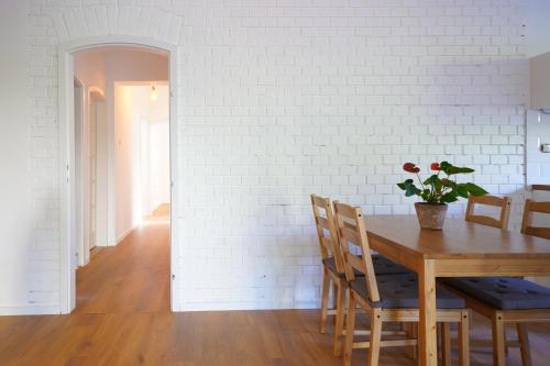 a dining room with a table and a white brick wall at Buda Side in Budakeszi