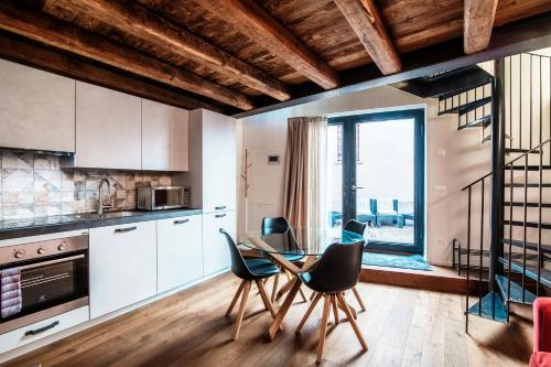 a kitchen with a table and chairs in a room at Lo Stallino by Quokka 360 - a stone's throw from the Hermann Hesse Museum in Montagnola