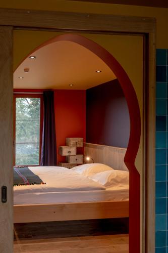 a bedroom with a large bed with an arch above it at Un air de bourlingueurs in Pepinster