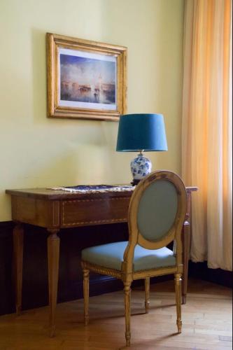 a lamp sitting on top of a desk with a chair at Anzolo Palace - Rooms & Apartments in Venice