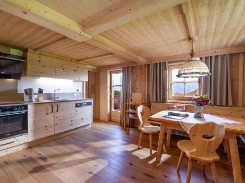 a kitchen with a wooden floor and a table and chairs at Biobauernhof Fleckl in Hopfgarten im Brixental