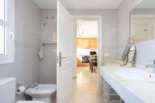 een witte badkamer met een wastafel en een toilet bij Nice Garden Valle del Sol in Adeje