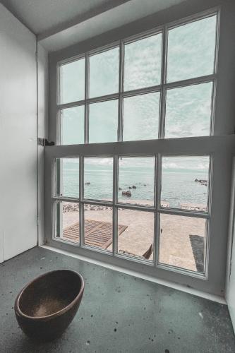 a room with a large window with a view of the beach at Adegas do Pico in São Roque do Pico