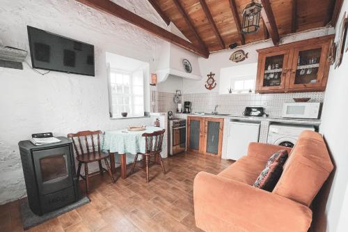 a kitchen with a couch and a table in a room at Adegas do Pico in São Roque do Pico