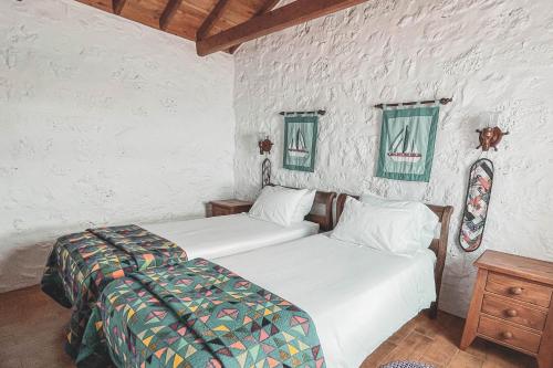 two beds sitting next to each other in a room at Adegas do Pico in São Roque do Pico