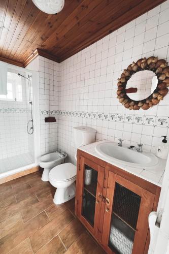 a bathroom with a toilet and a sink and a tub at Adegas do Pico in São Roque do Pico